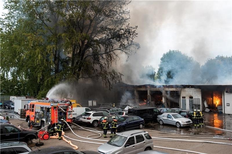 Feuerwehrleute löschen im Stadtteil Billbrook eine brennende Autowerkstatt. Foto: Bockwoldt/dpa