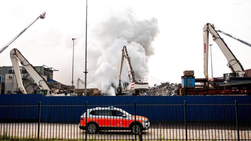 Feuerwehrleute löschen im Stadtteil Harburg einen brennenden Schrotthaufen. Der Brand war am Morgen auf dem Gelände, auf dem Altmetalle umgeschlagen werden, aus bisher ungeklärter Ursache in Brand geraten. 