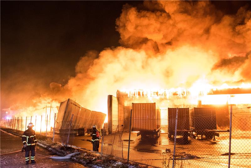 Feuerwehrleute löschen im Stadtteil Wilhelmsburg eine brennende Lagerhalle. Foto: Daniel Bockwoldt/dpa