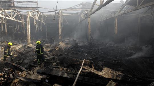 Feuerwehrleute löschen in Dnipro ein Feuer in einem zivilen Lager mit Haushaltsgegenständen, das am Vortag beschädigt wurde (Archivbild). 