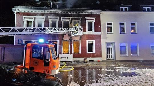 Feuerwehrleute löschen von einer Drehleiter aus ein Mehrfamilienhaus in Essen.
