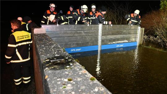 Feuerwehrleute schließen das Deichschart in Guderhandviertel/Neuhof an der Lühe.
