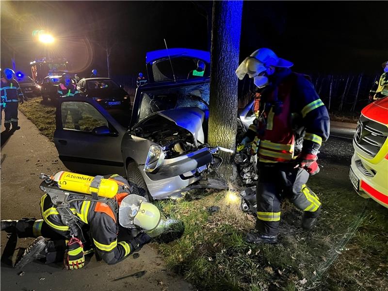 Feuerwehrleute sichern das Fahrzeug: Der Citröen Xsara prallte zwischen Ladekop und A 26-Anschlussstelle gegen einen Baum. Foto: Vasel