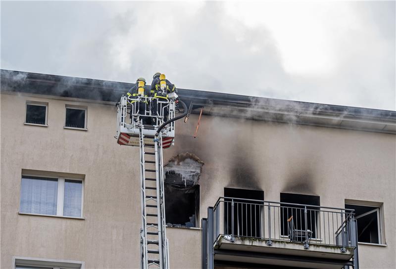 Feuerwehrleute sind bei einem Brand eines mehrstöckigen Wohnhauses im Stadtteil Jenfeld mit einer Drehleiter im Einsatz. Foto: Daniel Reinhardt/dpa