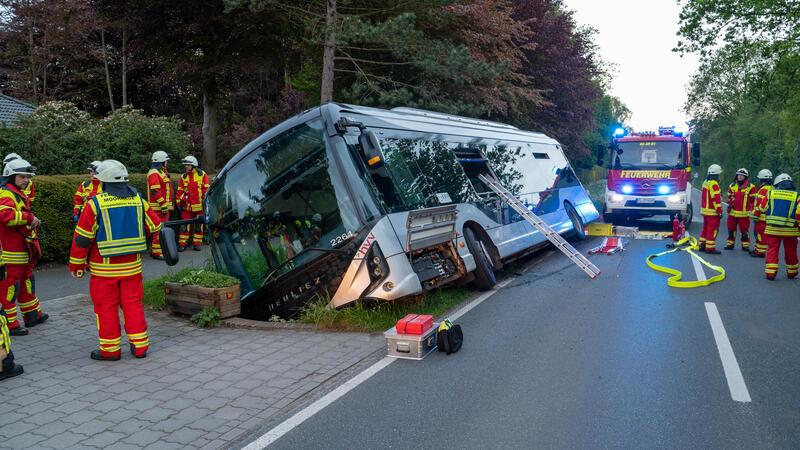 Linienbus rutscht in Graben: Sechs Fahrgäste verletzt Feuerwehrleute stehen bei einem Linienbus, der von der Straße abgekommen und in einem Graben gelandet war. Einige Personen sind bei dem Unfall verletzt worden.