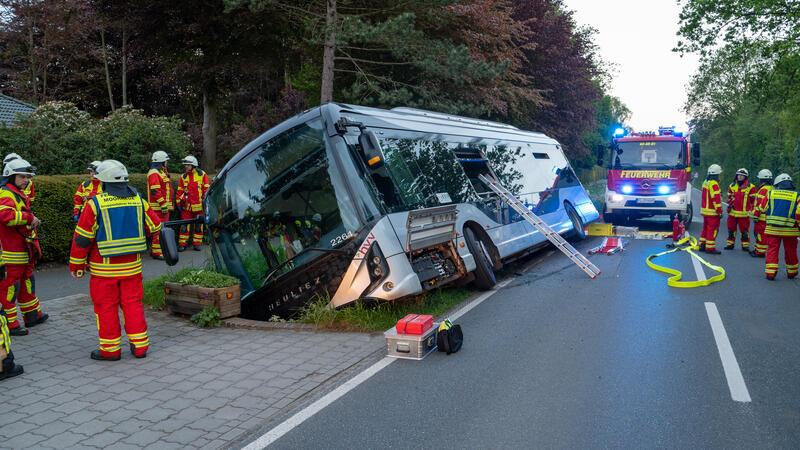 Feuerwehrleute stehen bei einem Linienbus, der von der Straße abgekommen und in einem Graben gelandet war. Einige Personen sind bei dem Unfall verletzt worden.