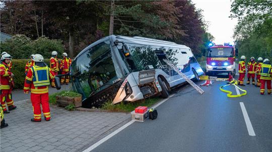 Feuerwehrleute stehen bei einem Linienbus, der von der Straße abgekommen und in einem Graben gelandet war. Einige Personen sind bei dem Unfall verletzt worden.