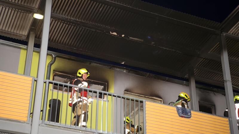 Brand in Geflüchtetenunterkunft: Ein Bewohner verletzt Feuerwehrleute stehen vor einer ausgebrannten Wohnung in Göttingen.