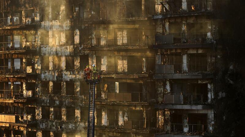 Feuerinferno mit mindestens neun Toten schockt Spanien Feuerwehrleute stehen während Löscharbeiten auf einer Hubleiter.