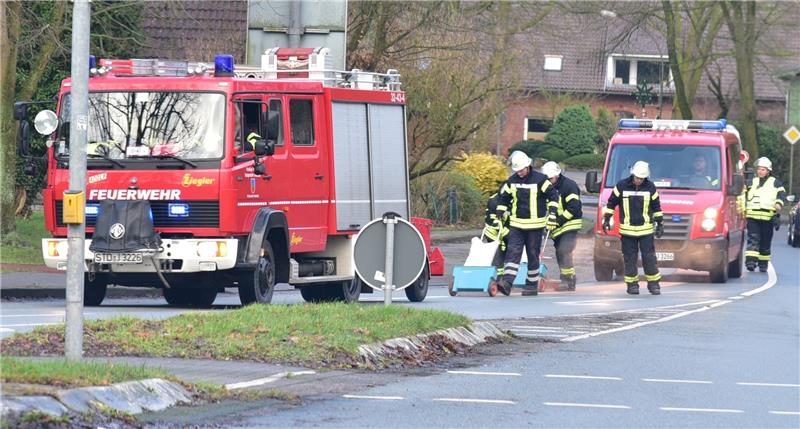 Feuerwehrleute streuen die Ölspur an der Hauptkreuzung in Fredenbeck ab. Foto Beneke