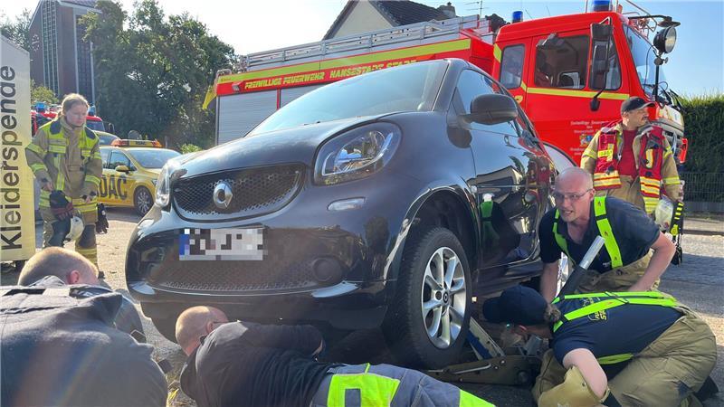 Feuerwehrleute und ADAC heben den Smart für die Katzenrettung in Stade-Hahle an.