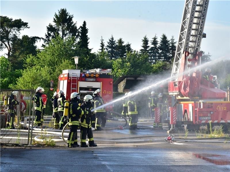 Zwei Lagerhallen in Kutenholz bei Großbrand vernichtet Feuerwehrleute unter schwerem Atemschutz bekämpfen den Brand in den renovierten Lagerhallen.