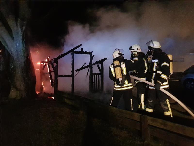 Feuerwehrleute unter schwerem Atemschutz löschen einen brennenden Holzschuppen in Fredenbeck. Umliegende Häuser bleiben verschont. Foto Beneke