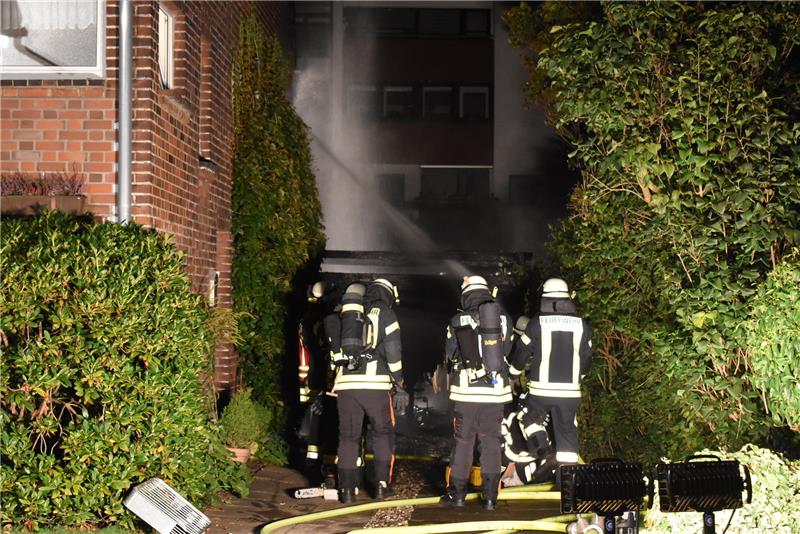 Feuerwehrleute verhindern ein Übergreifen des Feuers auf das Wohnhaus in der Giselbertstraße in Buxtehude. Foto: Vasel