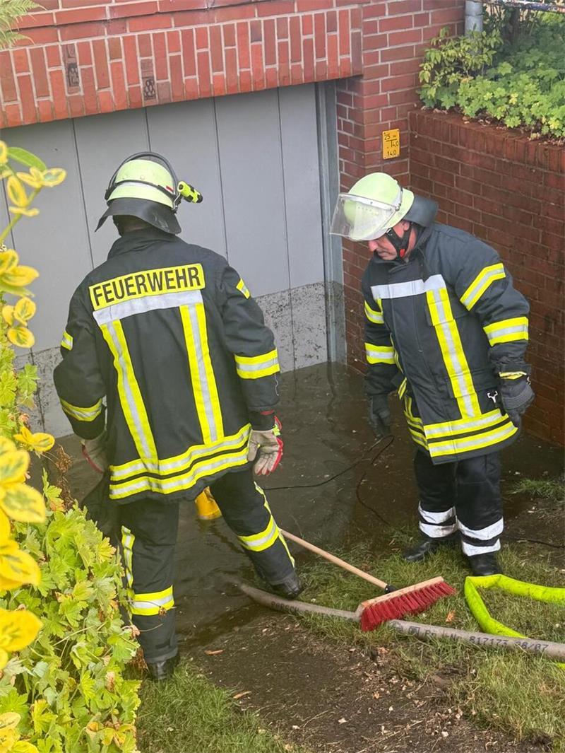 Feuerwehrleute vor einer überfluteten Garage in Düdenbüttel.