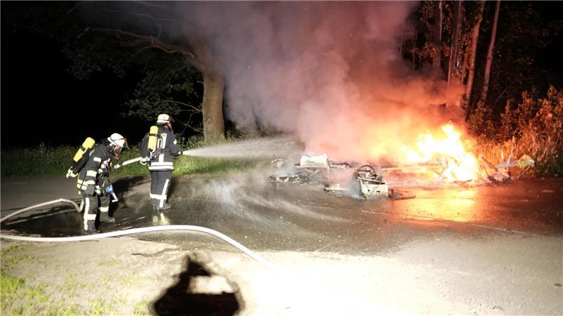 Feuerwehrmänner aus Himmelpforten löschen brennenden Wohnwagen.