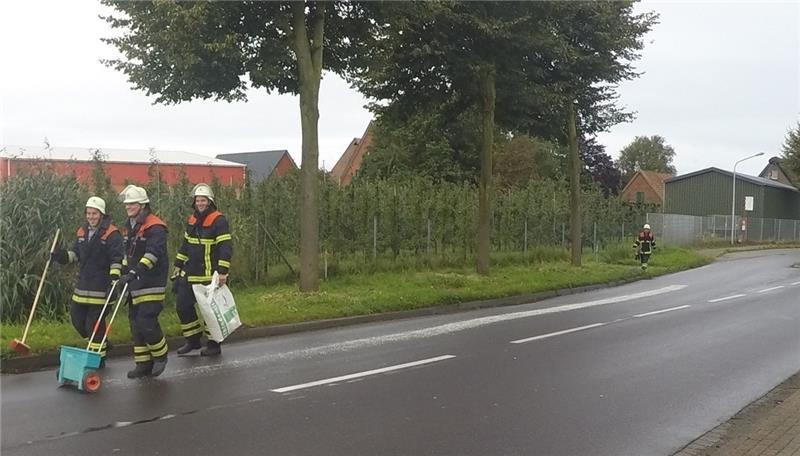 Feuerwehrmänner aus Mittelnkirchen streuen die Ölspur mit Bindemittel ab. Foto Lutz