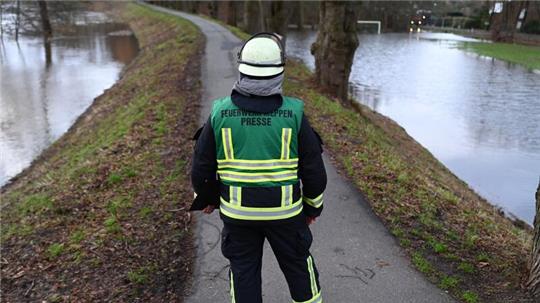 Feuerwehrmann Sven Lammers blickt auf den durchweichten Ems-Deich.