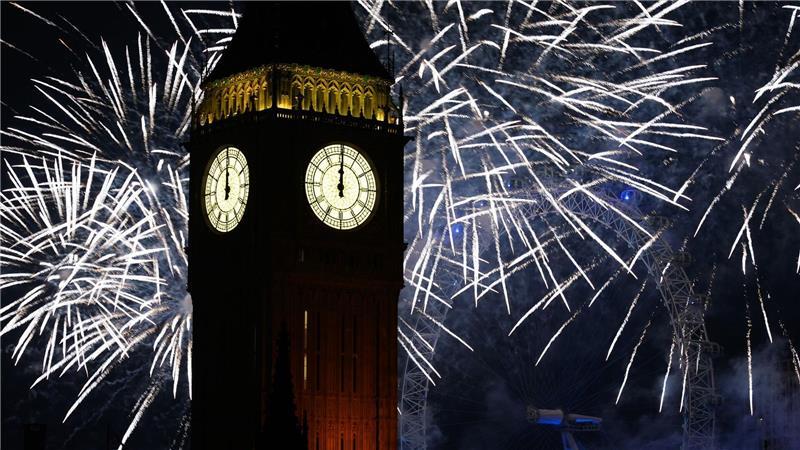 Feuerwerk erhellt den Himmel über dem Elizabeth Tower und dem London Eye im Zentrum Londons während der Neujahrsfeierlichkeiten.