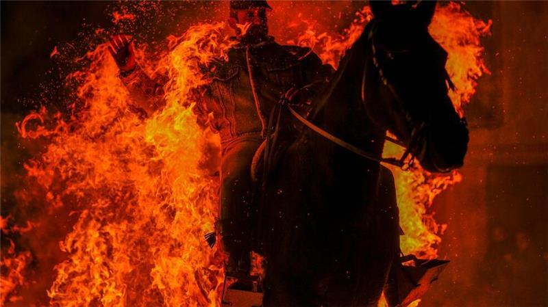 Feuriges Ritual: Mann reitet zu Ehren des Tier-Schutzpatrons durch Flammen