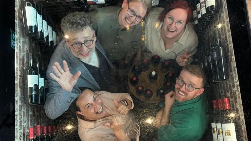 „Mein Lokal, Dein Lokal“: Wer den Wochensieg im Stader Nachbarkreis holt Finale für Ilir (unten rechts, im Uhrzeigersinn), Adriana, Claus, Dominique und Jasmin: Zum Abschied haben sich die „Mein Lokal, Dein Lokal“-Teilnehmer aus dem Cuxland für ein Foto in den nach oben hin verglasten Weinkeller des Wremer Ristorantes D‘Oro begeben.