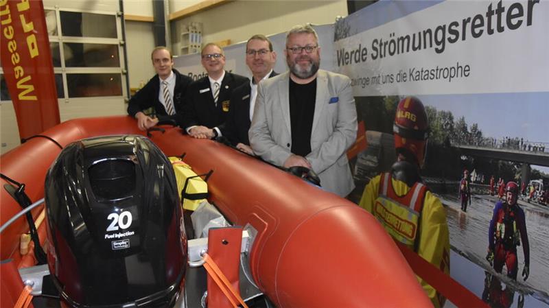 Finn Klüver und Jan Blanke von der DLRG Buxtehude mit Matthias Weiß von der Sparkasse Harburg-Buxtehude und dem Ersten Stadtrat Ralf Dessel (von links).