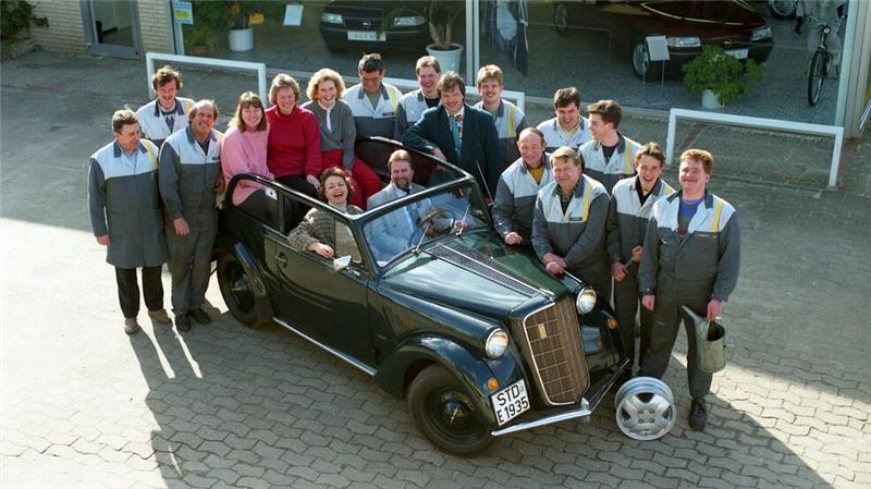 Firmenchefin Heike Brunsen-Berner 1993 auf dem Beifahrersitz eines Opel-Oldtimers mit der Belegschaft.