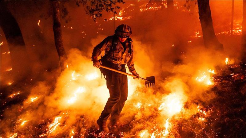 Bilder des Tages Flammen des Pickett-Feuers umzingeln einen Feuerwehrmann in Kalifornien.