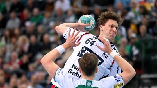 Flensburgs Lasse Möller setzt vor Leipzigs Luca Witzke zum Wurf an.
