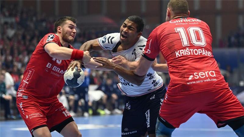 Melsungen gewinnt Spitzenspiel gegen Flensburg Flensburgs Mads Mensah Larsen (M) setzt sich gegen die Melsunger Elvar Örn Jonsson (l) und Dainis Kristopans durch.