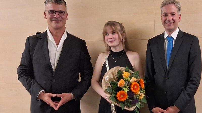 Flötistin Sofia Wolter, eingerahmt von den Dirigenten Andreas Désor und Hinnerk Otten (rechts).