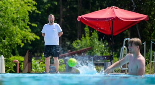 Florian Herbst, Fachangestellter für Bäderbetriebe, blickt auf ein Schwimmbecken im Freibad. Vielerorts werden händeringend Bademeister gesucht, viele Freibäder können wegen Personalmangels nicht öffnen. Foto: Philipp Schulze/dpa