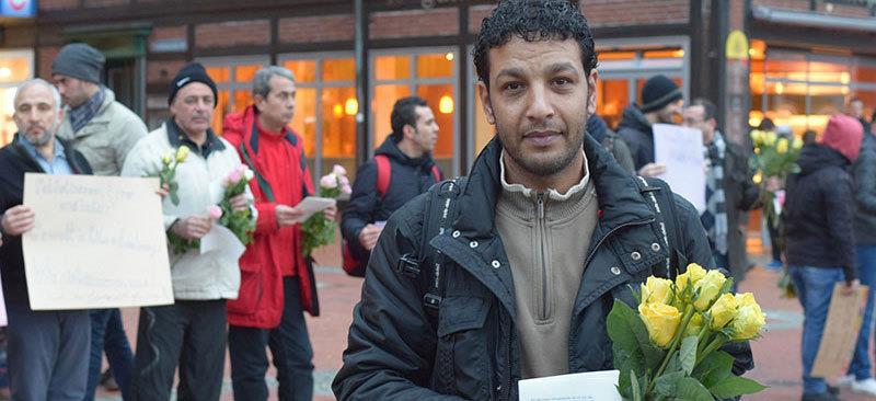 Flüchtlinge aus Stade – darunter Organisator Ayman Allaham – verteilen Rosen und Flugblätter. Foto von Borstel