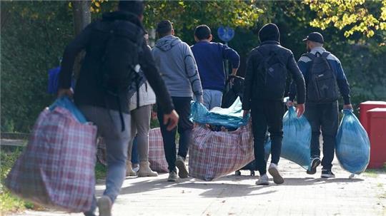Flüchtlinge aus Syrien gehen mit ihrem Gepäck zu der Erstaufnahmeeinrichtung in der Schmiedekoppel 30 im Stadtteil Niendorf.