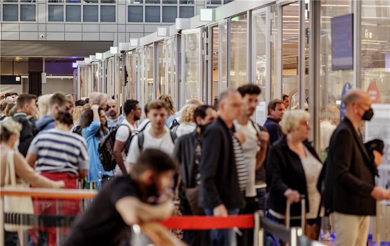 Fluggäste warten im Helmut Schmidt Flughafen vor dem Sicherheitscheck auf die Abfertigung. Foto: Axel Heimken/dpa