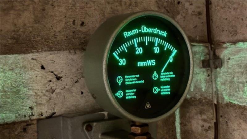 In der Buxtehuder Unterwelt: So sieht es im alten Bunker aus Fluoreszierende Stoffe an der Wand wirken noch heute und geben ein grünes Licht ab. Das Bild zeigt einen Manometer im Inneren des Bunkers. Ein Manometer ist ein technisches Druckmessgerät, das den Druck von Gasen oder Flüssigkeiten misst und anzeigt.