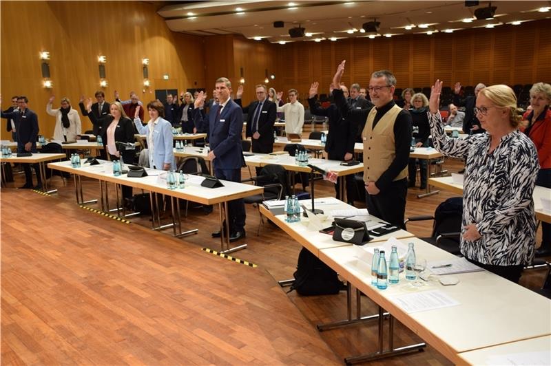 Förmliche Verpflichtung der neuen Ratsmitglieder im Stadeum: Sie stehen und heben die Hand. Foto: Strüning