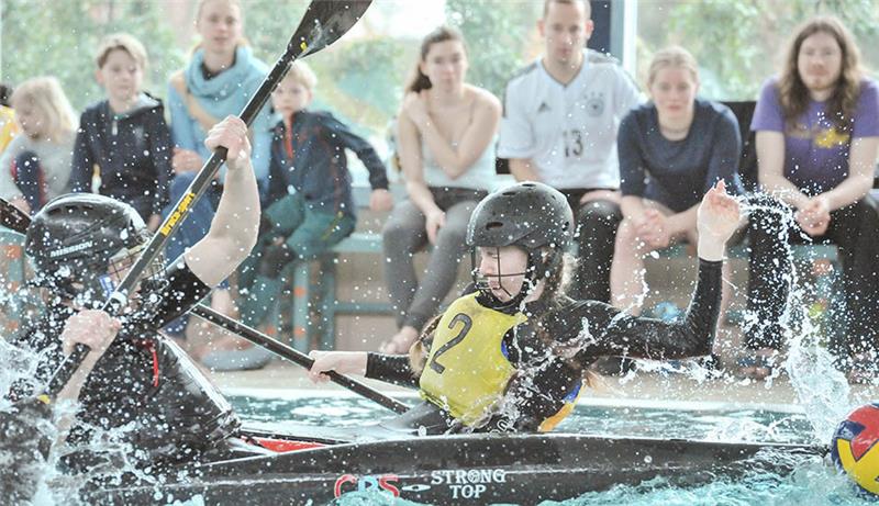 Buxtehuder Kanupolo-Teams setzen sich gegen Favoriten durch Foto aus der Wasserperspektive: Tobias Harzer von Buxtehude 2 (vorne) beobachtet, wie der gegnerische Spieler mit seinem Paddel einen Torwurf blocken will.