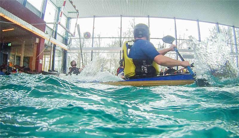 Buxtehuder Kanupolo-Teams setzen sich gegen Favoriten durch Foto aus der Wasserperspektive: Tobias Harzer von Buxtehude 2 (vorne) beobachtet, wie der gegnerische Spieler mit seinem Paddel einen Torwurf blocken will.