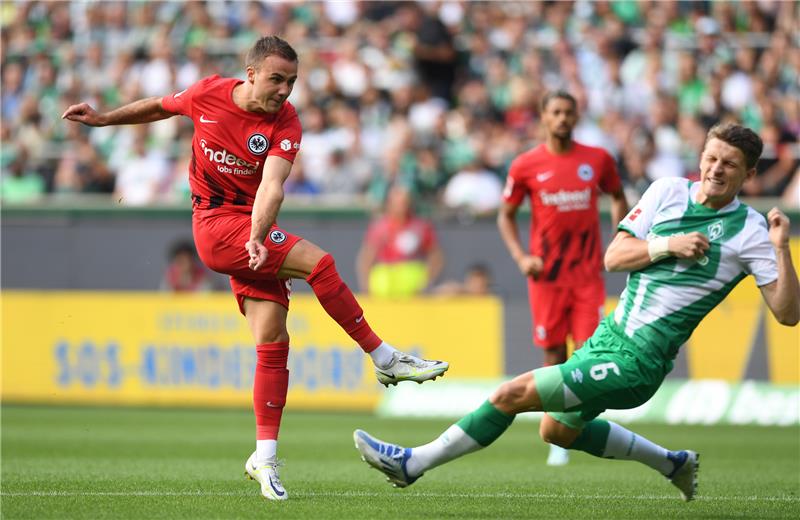 Frankfurts Mario Götze (l) erzielt gegen Werders Jens Stage das Tor zum 0:1. Foto: Carmen Jaspersen/dpa