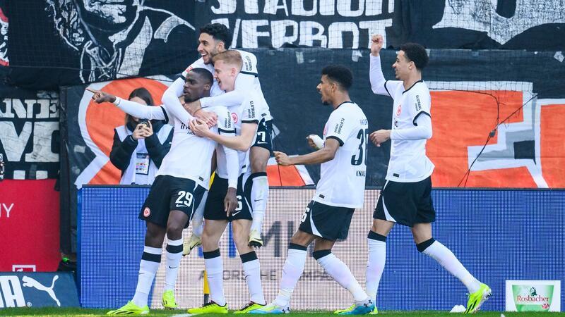 Frankfurts Niels Nkounkou (l) jubelt mit den Mitspielern, nachdem er für das temporäre 2:0 in Heidenheim gesorgt hat.