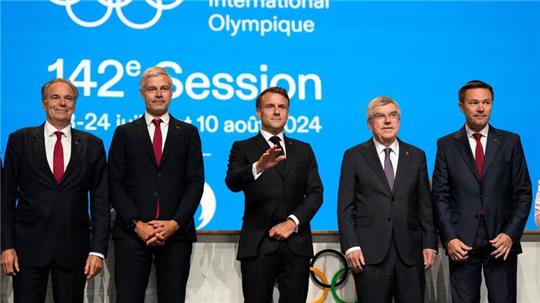 Frankreichs Olympia-Bewerber um Staatschef Emmanuel Macron (M) versprachen, die noch offenen Garantien für die Winterspiele zu gewähren.