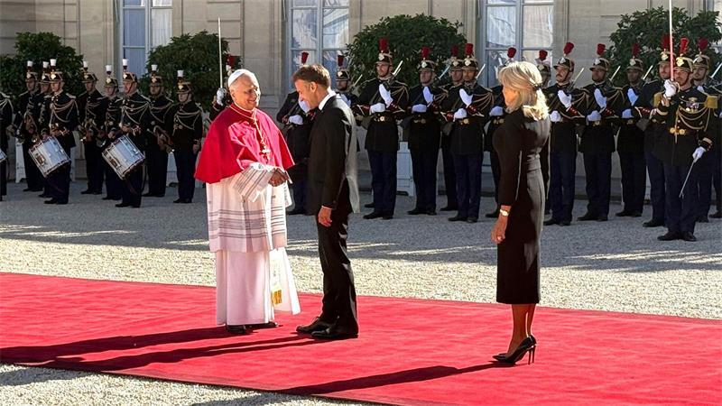 Papst mahnt in Frankreich zu „neuer Brüderlichkeit“ Frankreichs Präsident Emmanuel Macron und seine Ehefrau Brigitte schütteln Hände mit dem Papst im Hof des Élysée-Palastes.