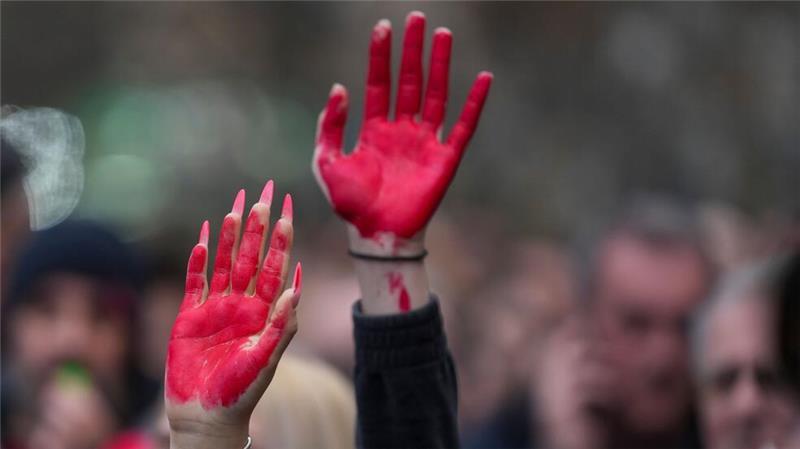 Frauen heben während einer Demonstration in Novi Sad ihre rot bemalten Hände.