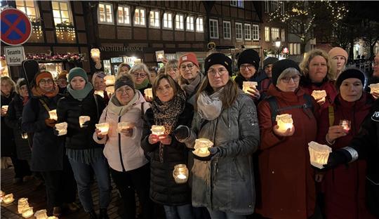 Frauen nehmen in Buxtehude an der Mahnwache zum Gedenken einer getöteten Mitbürgerin teil. Mit Teelichtern in den Händen bilden sie eine Lichterkette.
