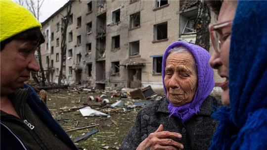 Frauen stehen in Lukiantsi in der Region Charkiw vor einem Haus, das durch einen russischen Luftangriff schwer beschädigt wurde.