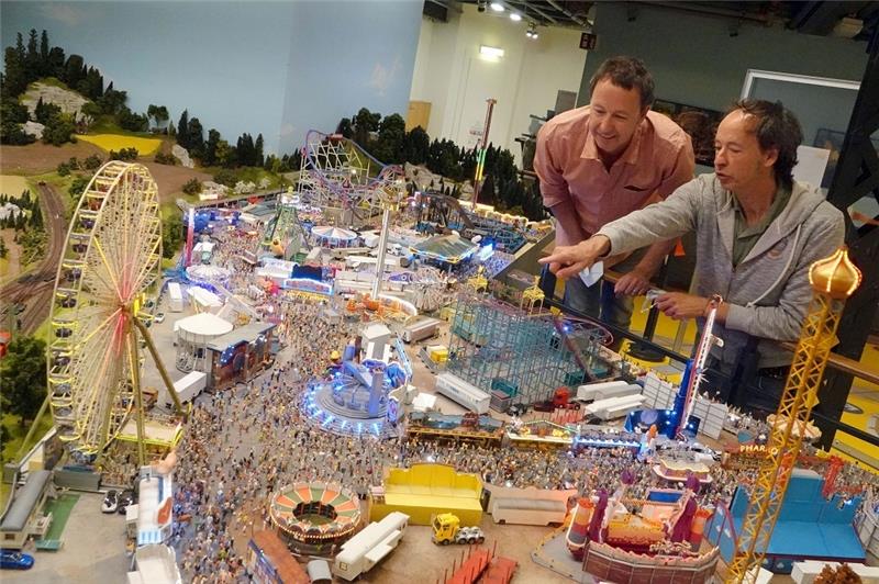 Frederik (l) und Gerrit Braun vom Miniatur Wunderland Hamburg betrachten die neue Kirmes. Jetzt haben sie einen Weltrekord aufgestellt. Foto: Jonas Klüter/dpa