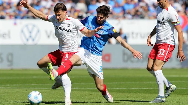 Freiburg siegt und besiegelt den Abstieg von Holstein Kiel Freiburgs Maximilian Eggestein (l) und Kiels Armin Gigovic kämpfen um den Ball.