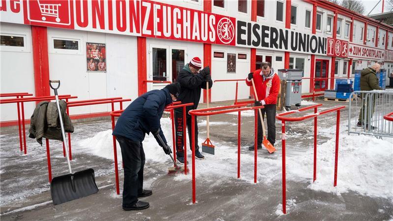 Absagen, Tickets, Kleidung: Bundesliga im Wetter-Stress Freiwillige Fans des 1. FC Union befreien Wege und Parkplätze am und im Stadion An der Alten Försterei von Schnee.