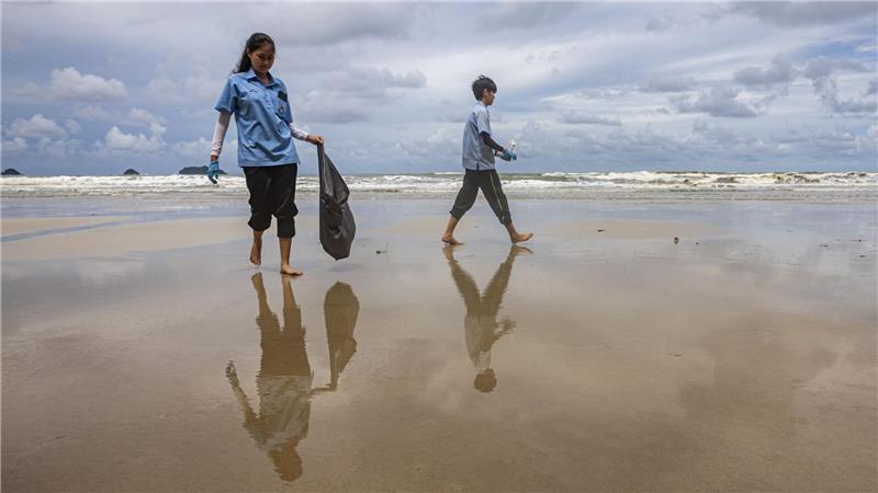 Freiwillige Helfer sammeln im Rahmen einer inselübergreifenden Initiative zum Weltozeantag Müll an einem Strand von Koh Chang in Thailand.